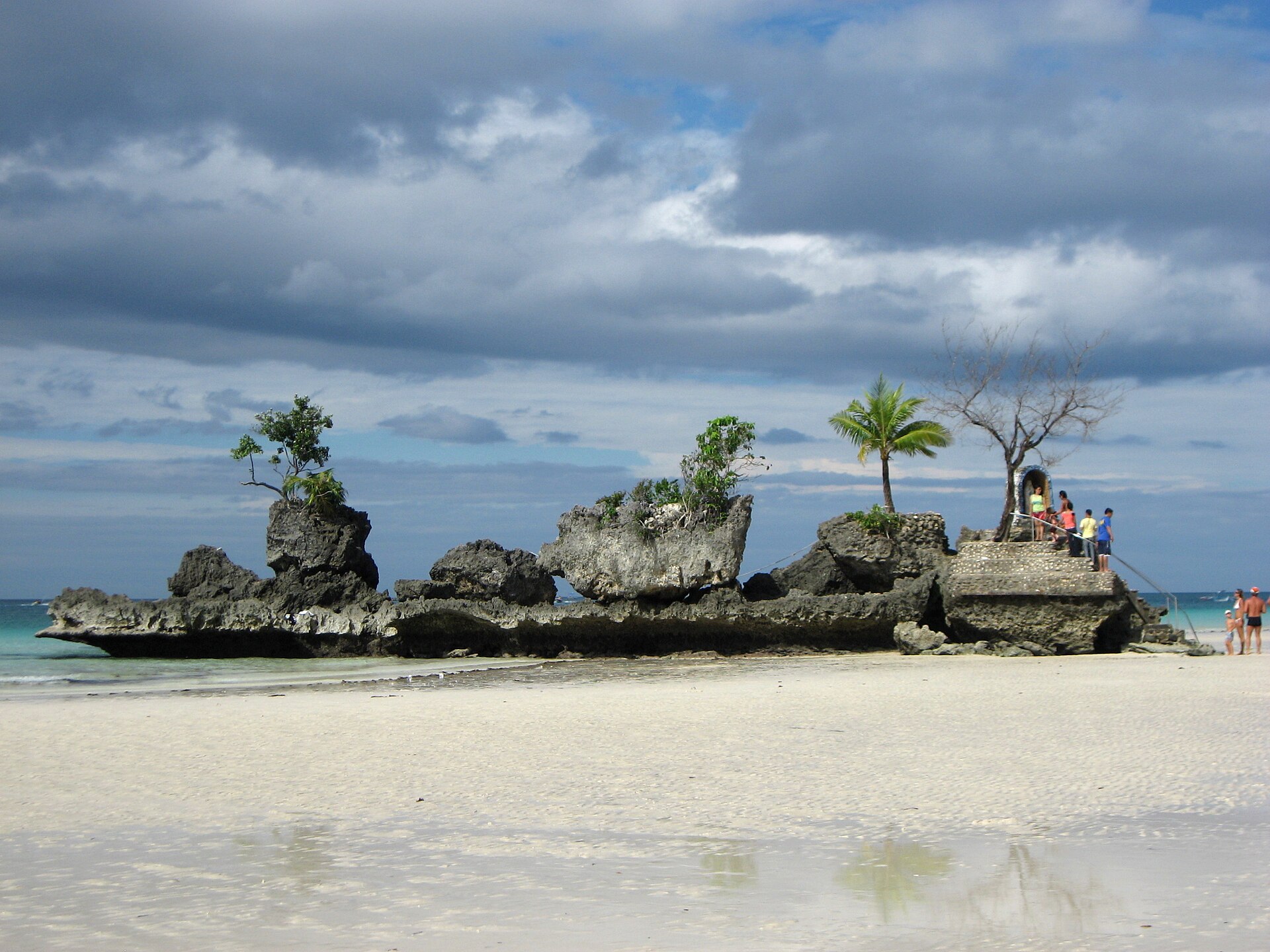 Willy's Rock at low tide on White Beach, Boracay, a coral outcrop with a small shrine