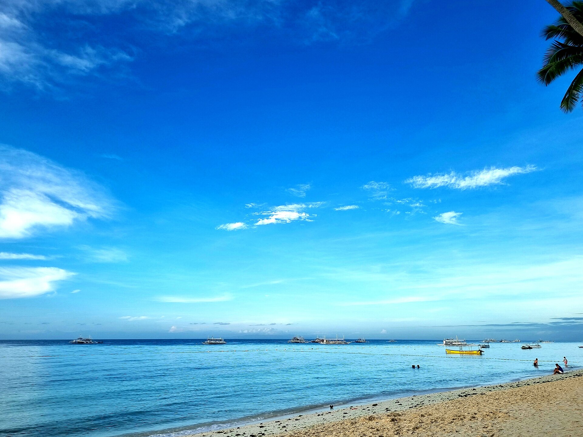 Alona Beach, Panglao, a sandy shore with boats anchored offshore